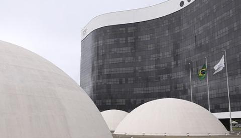 Fachada do edifício-sede do Tribunal Superior Eleitoral, em Brasília, com as cúpulas em primeiro plano e bandeiras hasteadas
