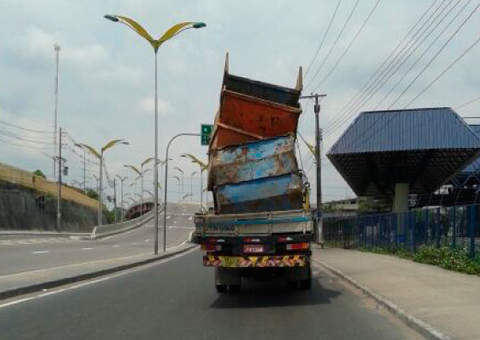 Caminhão transporta caçambas sem nenhuma segurança