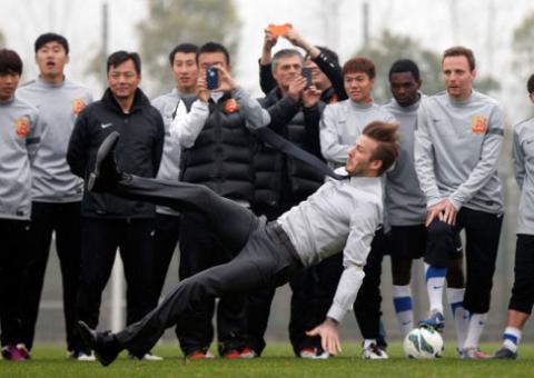 David Beckham paga mico ao cair durante demonstração de lance livre na China
