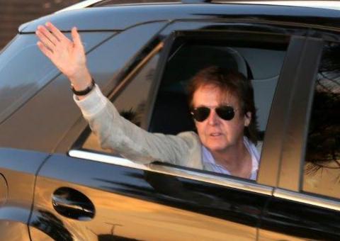 Escoltado pela polícia, Paul McCartney acena para fãs ao chegar no Estádio em Goiânia