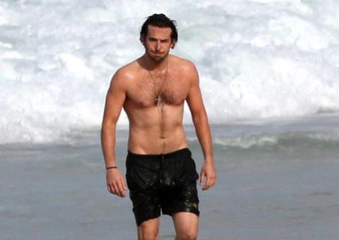 Curtindo o Brasil, Bradley Cooper se refresca no mar de Ipanema