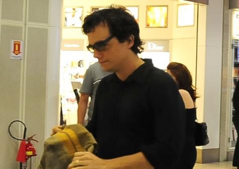  Fugindo dos paparazzi, Wagner Moura tenta passar despercebido em aeroporto