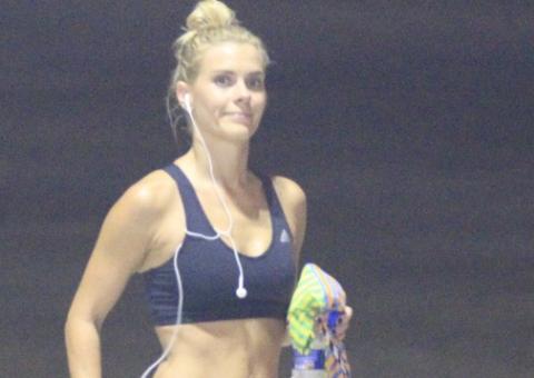  Carolina Dieckmann sua a camisa na praia com ajuda de personal trainer