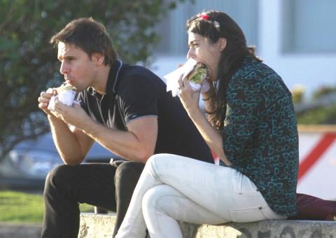  Acompanhado de amiga, Murilo Rosa devora sanduíche na orla da praia