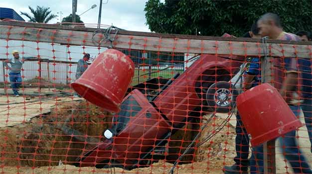 Carro cai em vala no meio da rua, na zona Norte