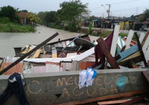 Igarapé do 40 transborda e arrasta casa