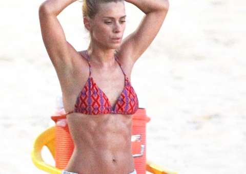  Carolina Dieckmann exibe barriga sarada em dia de treino na praia