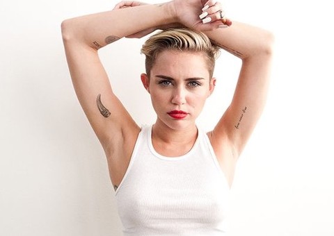 Miley Cyrus mostra os peitos deitada no colo de amiga 