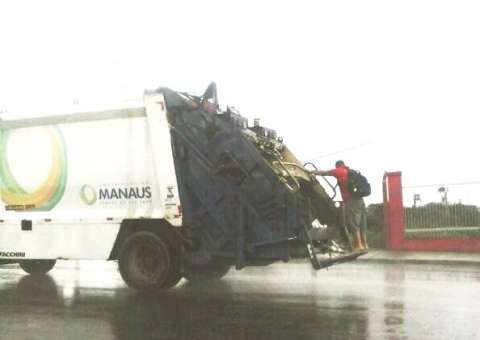 ‘Confiado’ pega carona no caminhão do lixo e atende celular