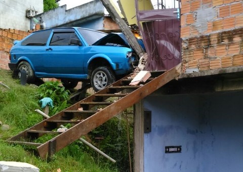 Carro desgovernado desde ladeira e fica preso na entrada de uma casa