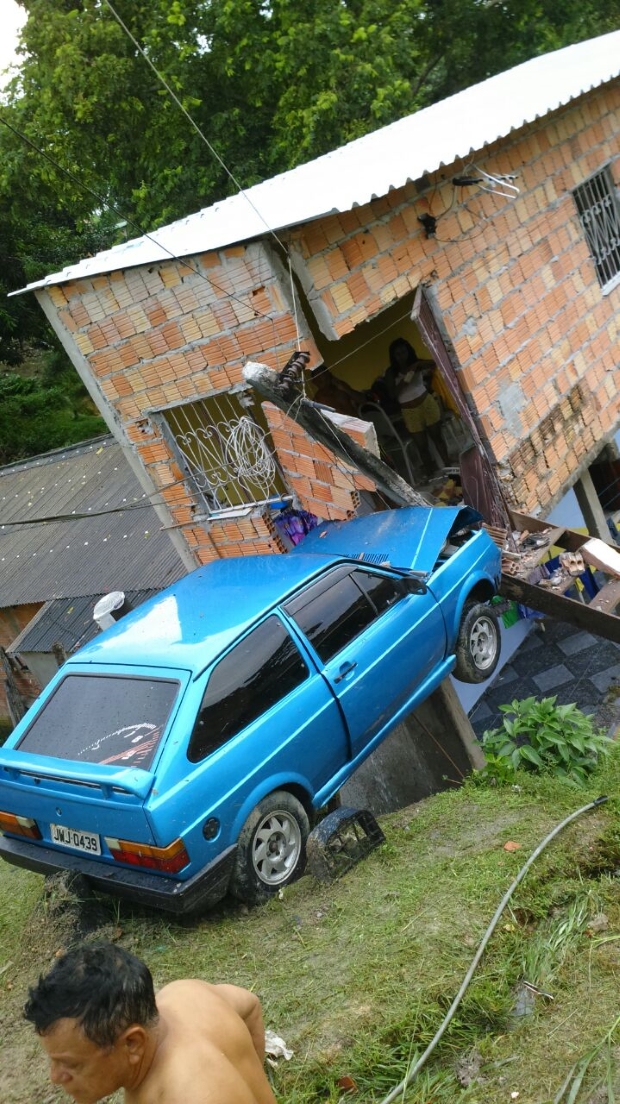 Carro desgovernado desde ladeira e fica preso na entrada de uma casa