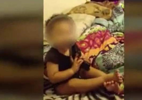 Vídeo mostra pais estimulando a filha de um ano a colocar revólver na boca