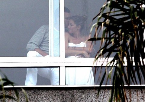 Gisele Bündchen troca carícias com marido em varanda de hotel