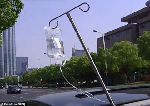 Flagrante no trânsito: Homem dirige com um gotejador de soro saindo pelo teto do carro e conectado a mão