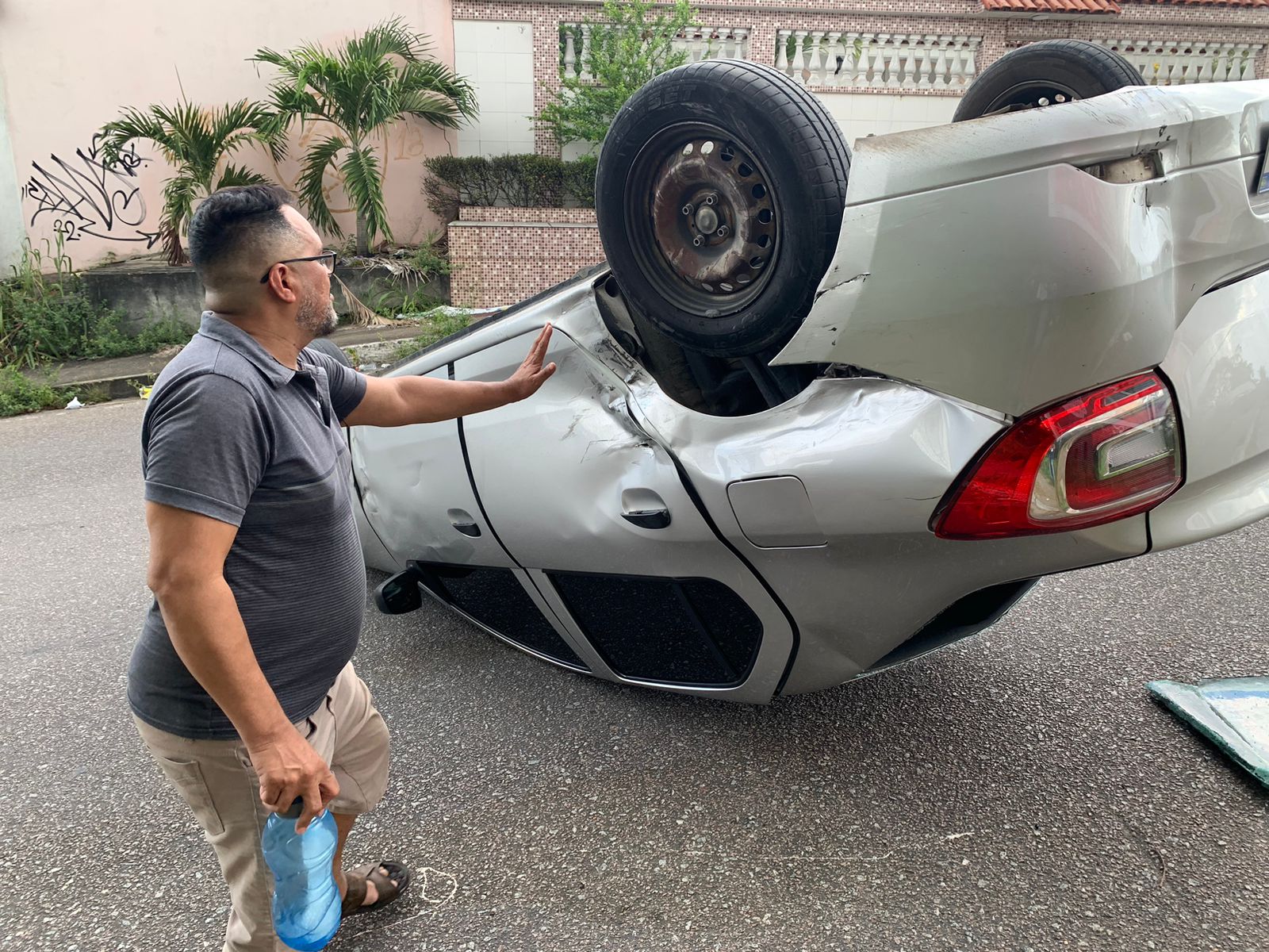 Motorista mostra carro capotado na via. Foto: Caio Guarlotte/ Portal do Holanda