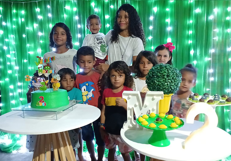 A m&atilde;e de Maxuel, com o menino no colo, e amiguinhos, em uma de suas festinhas &mdash; Foto: Arquivo pessoal