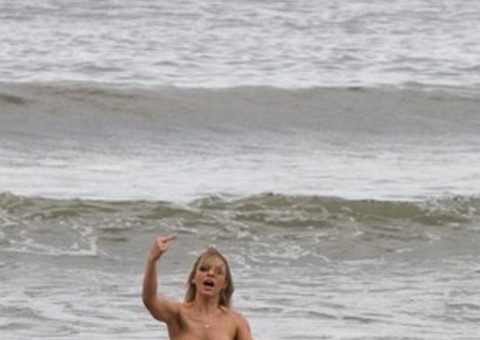 Miss Bumbum 2014 é flagrada pelada na praia e faz gesto obsceno para fotógrafo