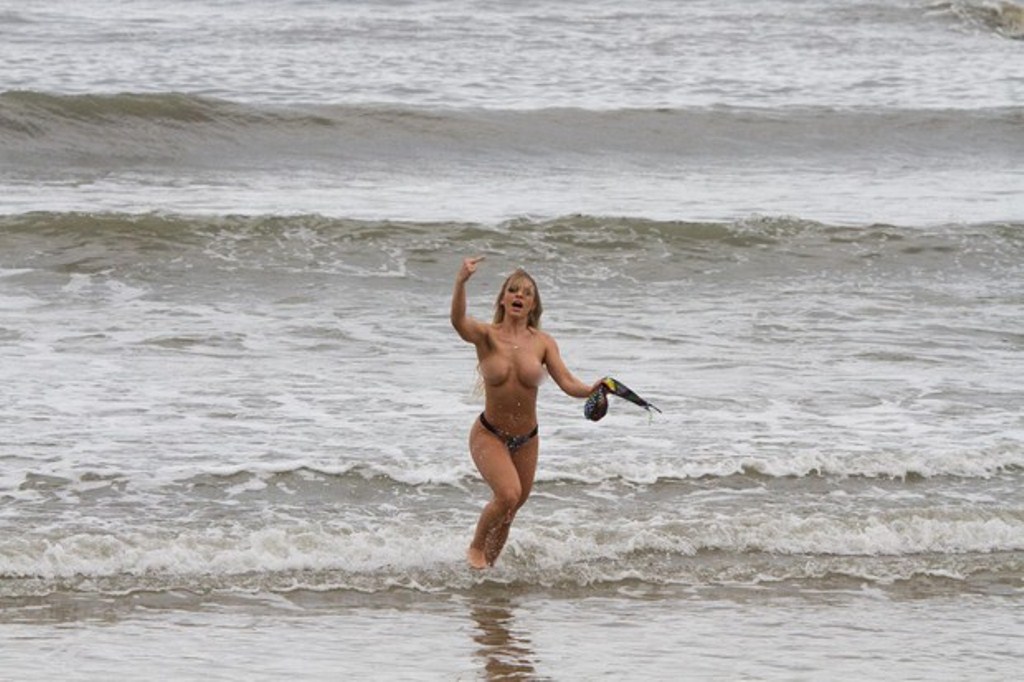 Miss Bumbum 2014 é flagrada pelada na praia e faz gesto obsceno para fotógrafo