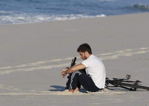 Klebber Toledo é visto pensativo na praia e sem aliança