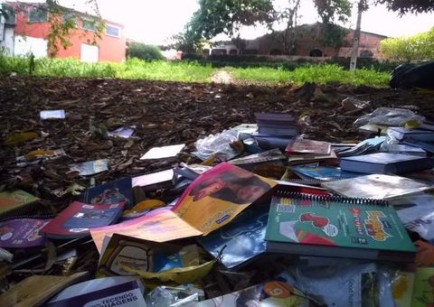 Livros didáticos são descartados em área verde