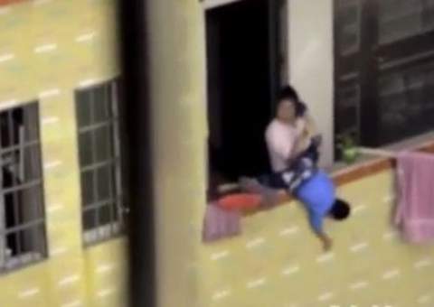Mãe enlouquece e é filmada ameaçando jogar o filho da janela; assista