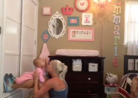 Unindo o útil ao agradável: Mãe malha enquanto dá amor para filha.