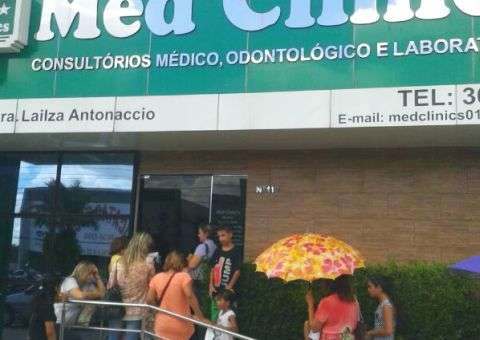 Clientes de clínica esperam por atendimento sob  o sol
