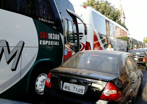 Ônibus de turistas interditam rua 10 de Julho