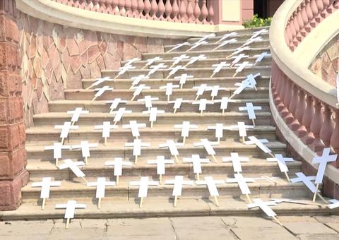 Cruzes são estendidas na escadaria do Teatro Amazonas em ato contra mortes por Covid-19 