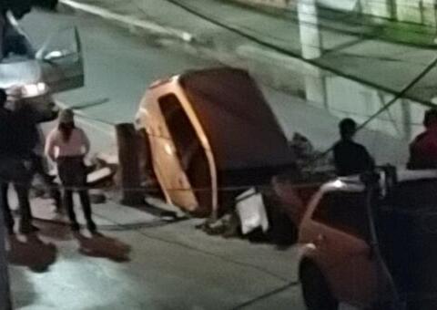 Carro despenca em cratera no meio de avenida