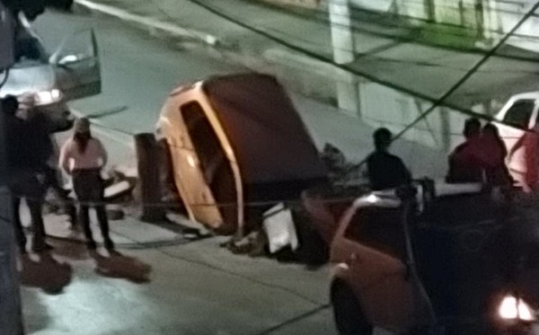 Carro despenca em cratera no meio de avenida