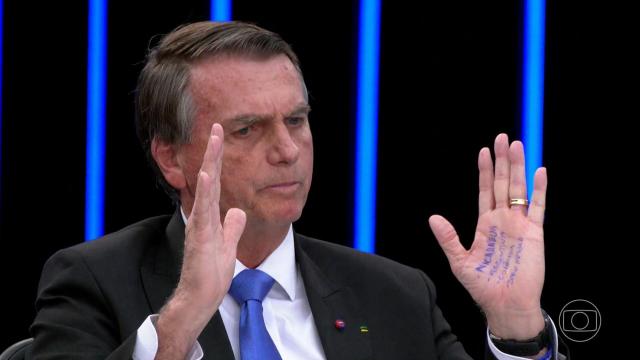 Bolsonaro mostra cola anotada a caneta em sua mão no dia seguinte ao JN