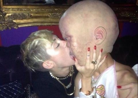 Miley Cyrus beija homem fantasiado de 'bebê gigante'