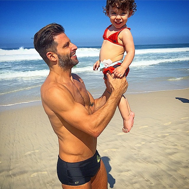 Pai babão, Henri Castelli posa com a filha em dia de praia