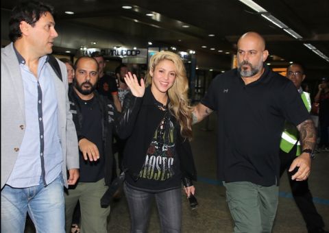 Shakira desembarca sorridente no Brasil e é cercada por fãs