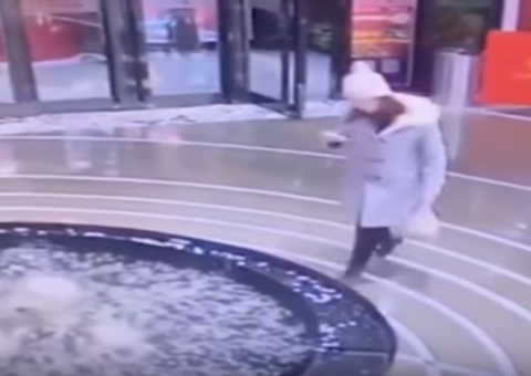 Mulher se distrai com celular e cai em fonte em shopping