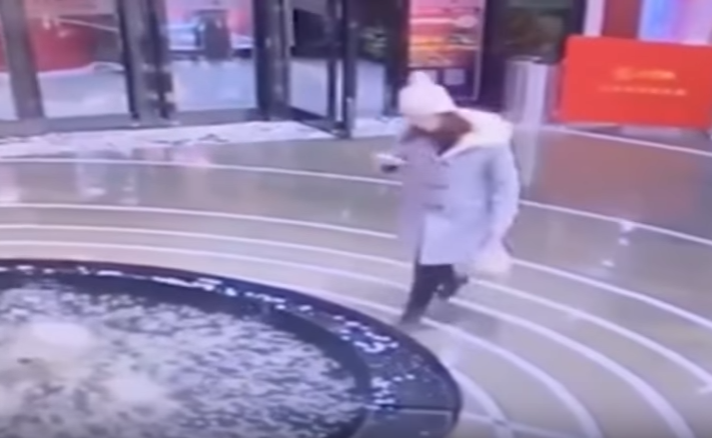 Mulher se distrai com celular e cai em fonte em shopping