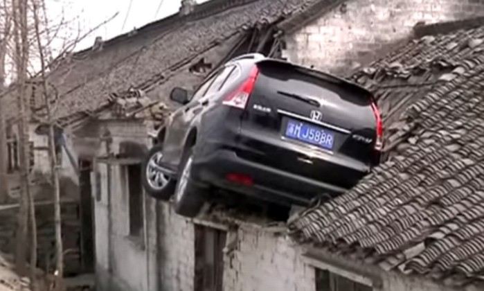 Motorista tenta desviar de acidente e carro vai parar em telhado de casa