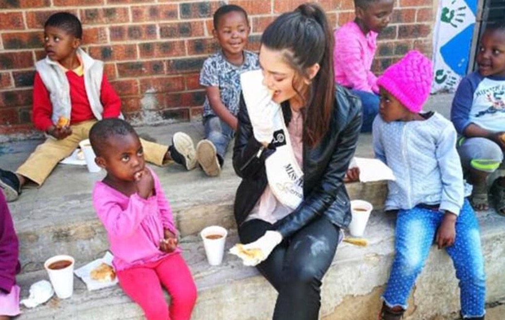 Miss causa polêmica ao usar luvas para encontrar órfãos com HIV 