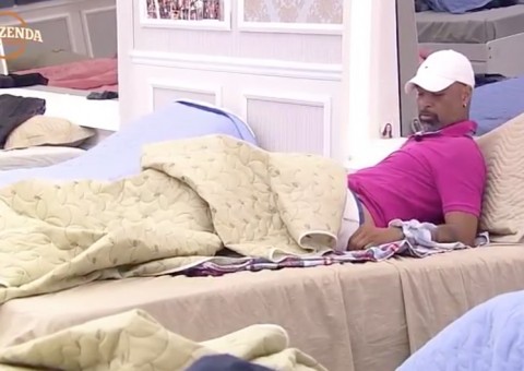 Dinei deixa foto de Monique ao lado da cama e vai para debaixo do edredom