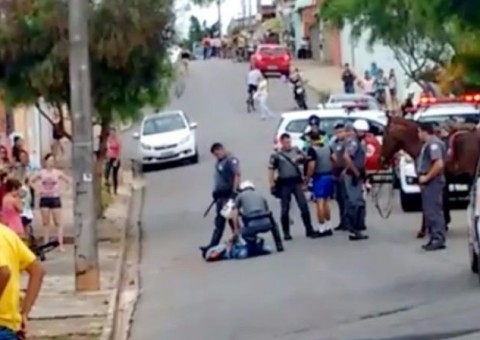 Homem é espancado em rua após 'guerra de tijoladas' com a polícia
