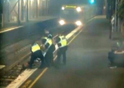 Mulher bêbada é retirada de trilhos momentos antes da chegada de trem