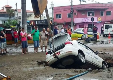 Após adutora romper, cratera se abre em rua e engole táxi