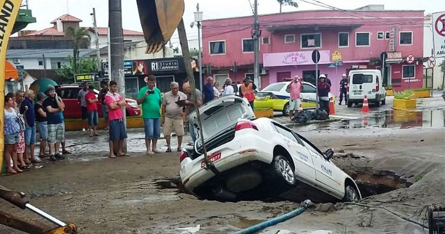 Após adutora romper, cratera se abre em rua e engole táxi