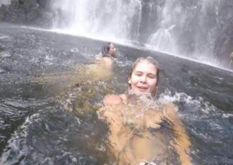 Mulher tira selfie enquanto pessoa se afoga atrás dela