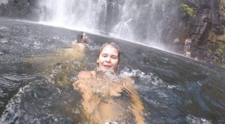 Mulher tira selfie enquanto pessoa se afoga atrás dela