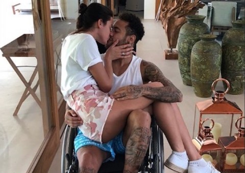 Em cadeira de rodas, Neymar posa com aos beijos com Bruna Marquezine