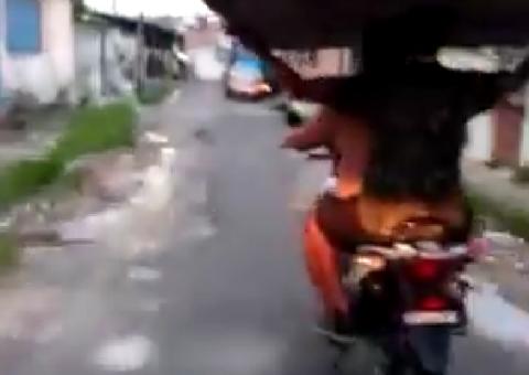 Em cima de moto, manauara é flagrado carregando cama de casal na cabeça
