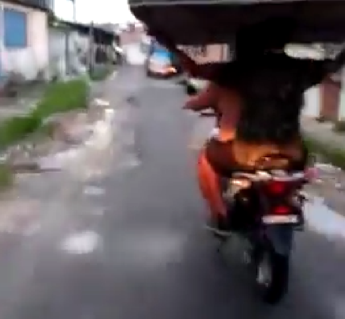 Em cima de moto, manauara é flagrado carregando cama de casal na cabeça