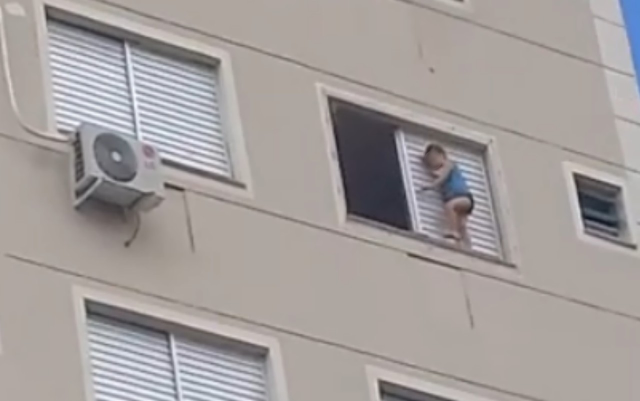 Criança é flagrada andando do lado de fora de janela de prédio